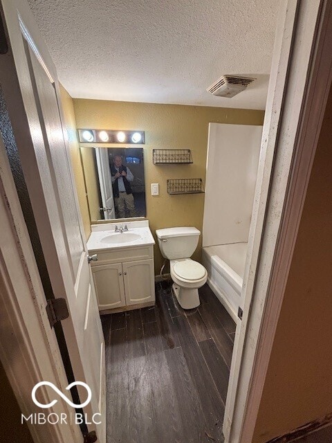 3302 E 42nd St, Indianapolis, IN 46205 - full bathroom with visible vents, toilet, a textured ceiling, wood finished floors, and vanity