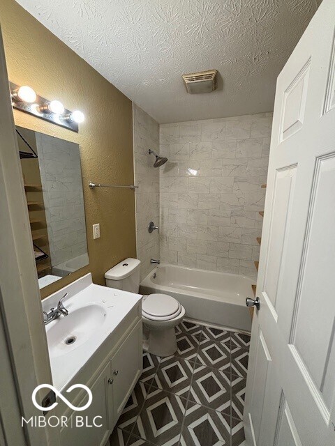 3302 E 42nd St, Indianapolis, IN 46205 - full bath with visible vents, toilet, a textured ceiling, vanity, and a textured wall