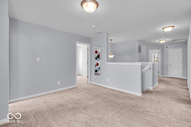 unfurnished room featuring visible vents, baseboards, and light colored carpet