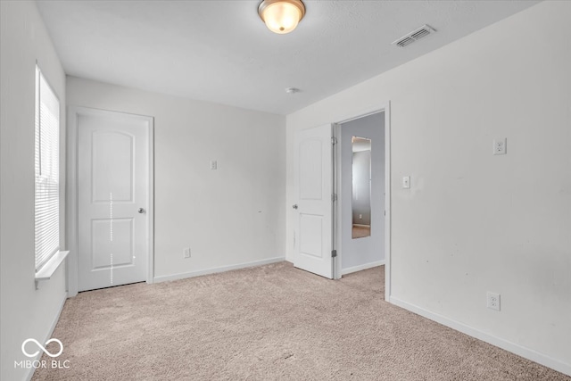 unfurnished bedroom with visible vents, baseboards, and carpet