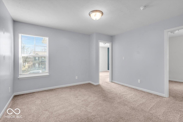 unfurnished room with baseboards and carpet flooring