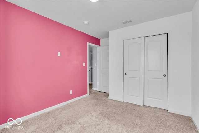 unfurnished bedroom featuring a closet, visible vents, baseboards, and carpet floors