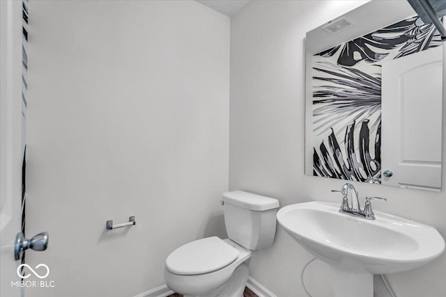 bathroom with a sink, baseboards, and toilet