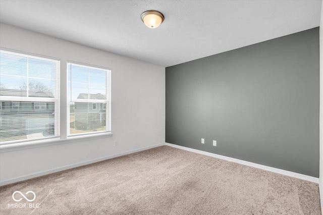 empty room featuring carpet flooring and baseboards