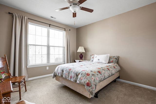 carpeted bedroom with visible vents, a ceiling fan, and baseboards