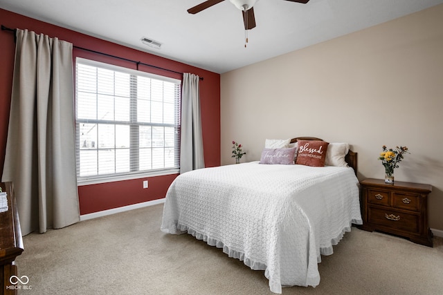 carpeted bedroom with visible vents, baseboards, and a ceiling fan