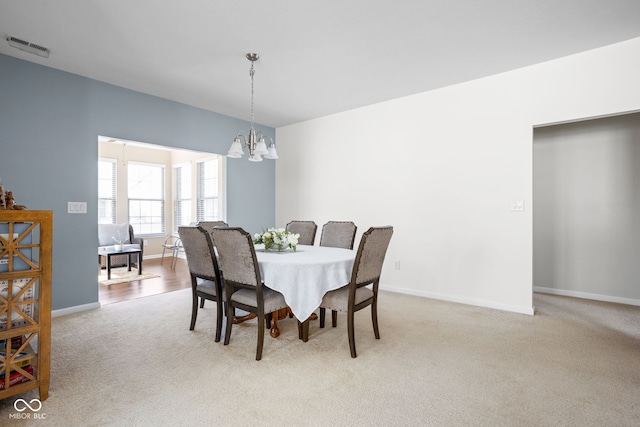 dining room featuring carpet, a notable chandelier, baseboards, and visible vents