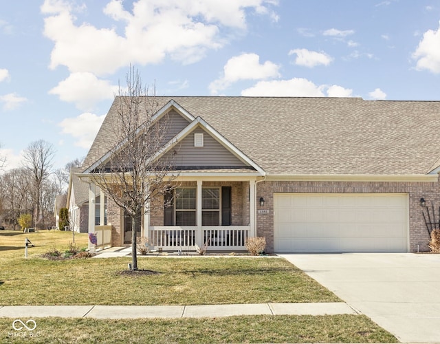 view of front of home with a front yard, brick siding, covered porch, and driveway