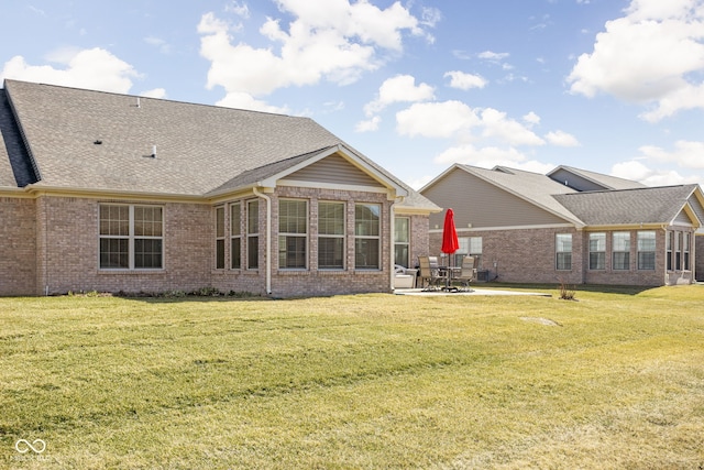 back of house with a patio area, brick siding, and a lawn