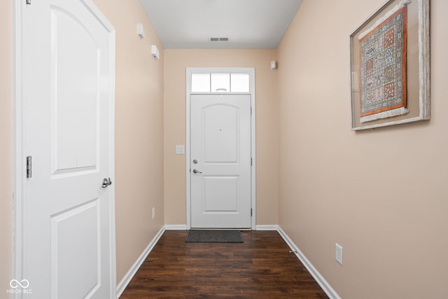 doorway with dark wood-type flooring, baseboards, and visible vents