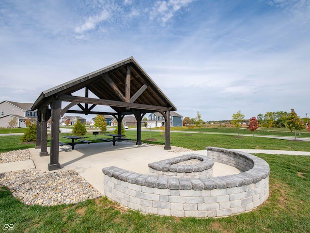 view of community with a gazebo, a lawn, and an outdoor fire pit