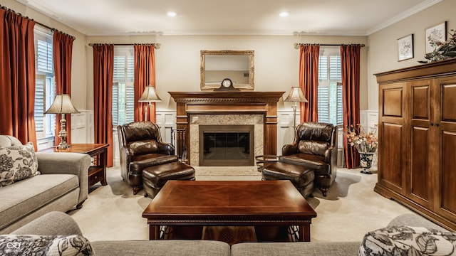 living room featuring light carpet, a wainscoted wall, a premium fireplace, and ornamental molding