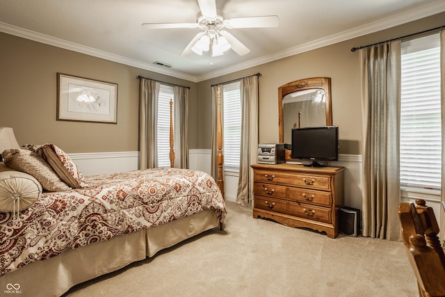 carpeted bedroom with visible vents, a ceiling fan, and ornamental molding