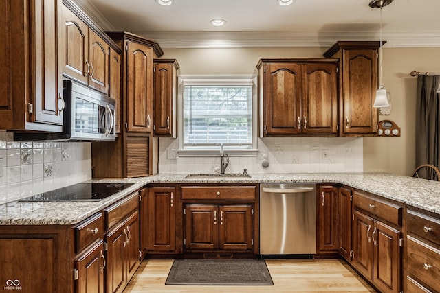 kitchen featuring a sink, crown molding, light wood-style flooring, and stainless steel appliances