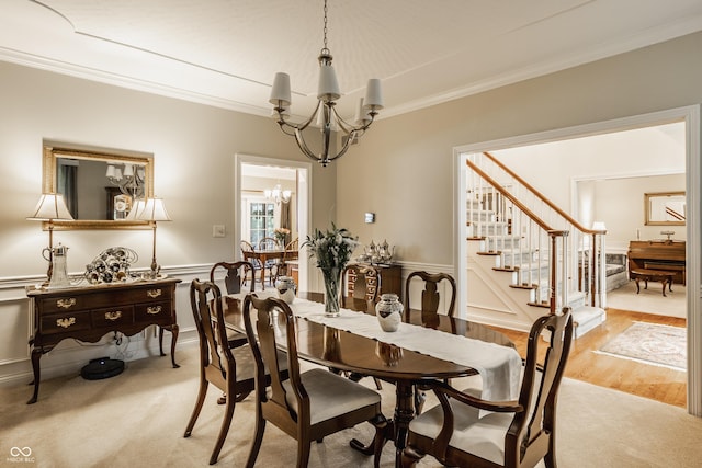 dining area with light wood finished floors, crown molding, stairs, light carpet, and an inviting chandelier