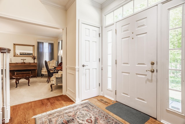 foyer featuring light wood-type flooring and crown molding