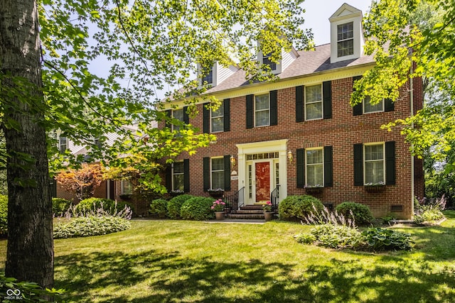 colonial home with brick siding, crawl space, and a front lawn