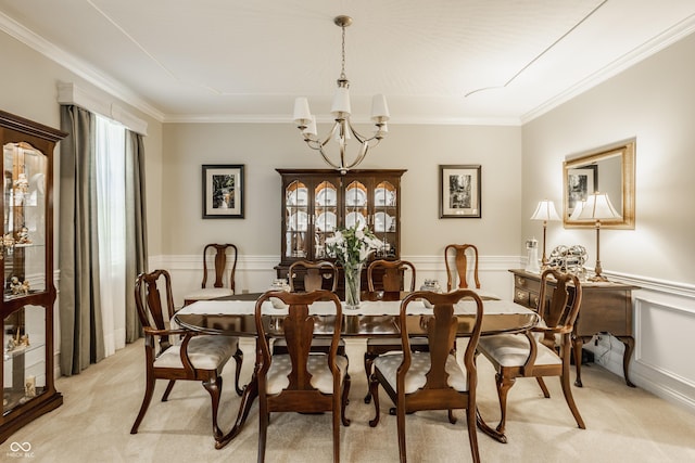 dining area featuring a wainscoted wall, light colored carpet, crown molding, and an inviting chandelier