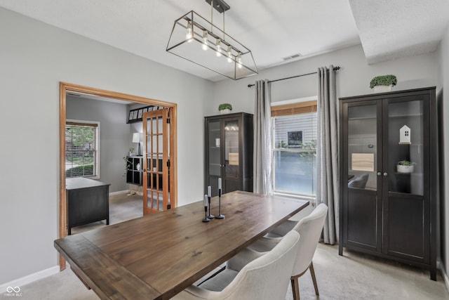 dining area featuring light colored carpet, baseboards, and visible vents