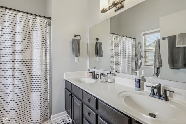 full bath featuring a sink, curtained shower, and double vanity