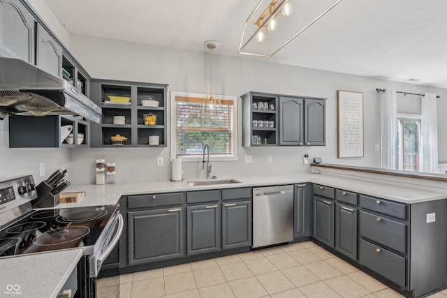 kitchen with open shelves, a peninsula, gray cabinets, a sink, and appliances with stainless steel finishes