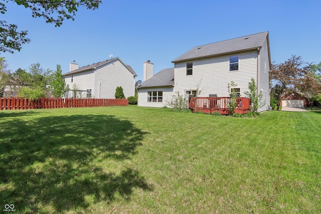 back of house with a yard, fence, a wooden deck, and roof with shingles