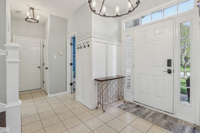 foyer with light tile patterned floors, visible vents, and a notable chandelier