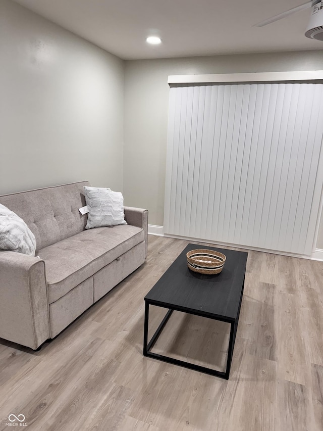 living area featuring recessed lighting, baseboards, and wood finished floors