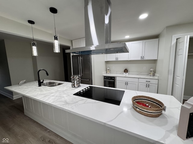 kitchen with wood finished floors, a sink, black appliances, white cabinetry, and island range hood