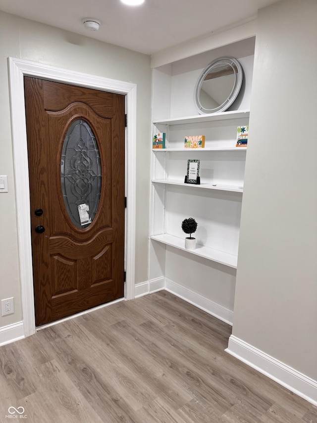 foyer with wood finished floors and baseboards