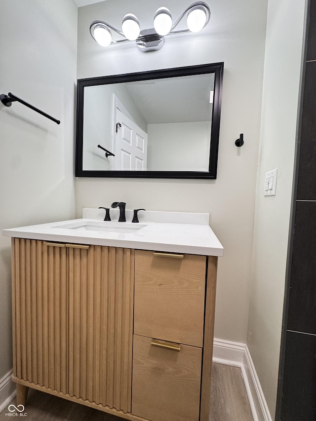 bathroom featuring vanity, baseboards, and wood finished floors