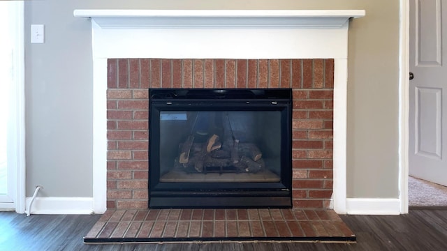 room details with a fireplace, baseboards, and wood finished floors