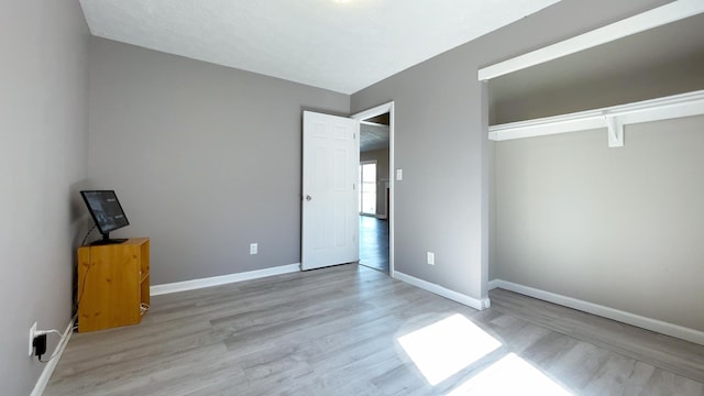 unfurnished bedroom with wood finished floors and baseboards