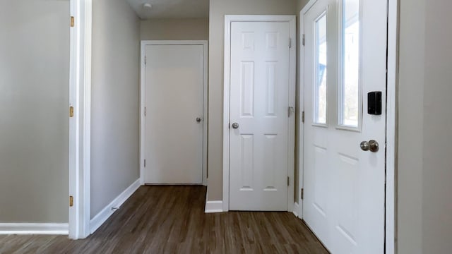 foyer with dark wood-style floors and baseboards