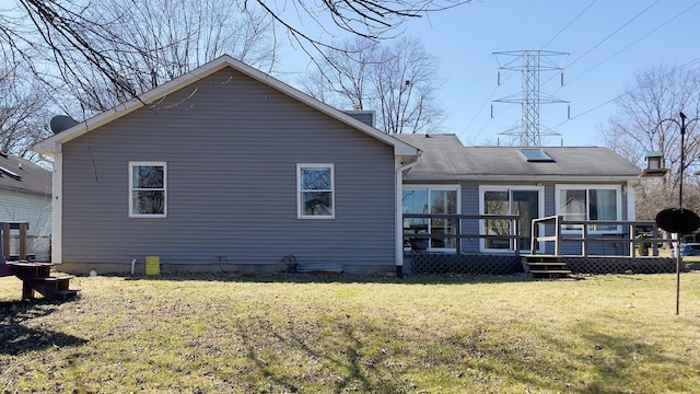 rear view of house with a yard and a wooden deck