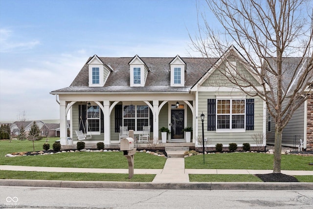 view of front of home featuring a porch, a front lawn, and a shingled roof