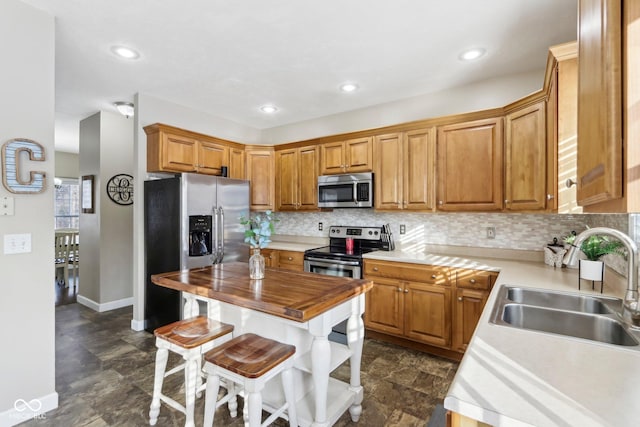 kitchen featuring a sink, tasteful backsplash, wood counters, and stainless steel appliances