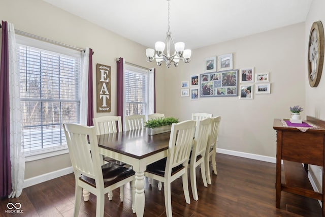 dining area with baseboards, an inviting chandelier, and wood finished floors