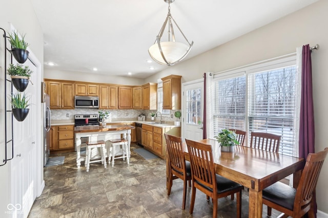 kitchen with decorative backsplash, light countertops, a sink, and stainless steel appliances