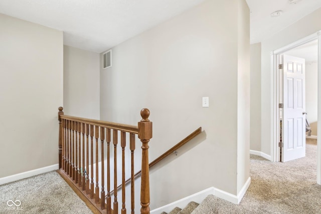 stairs featuring baseboards, visible vents, and carpet floors