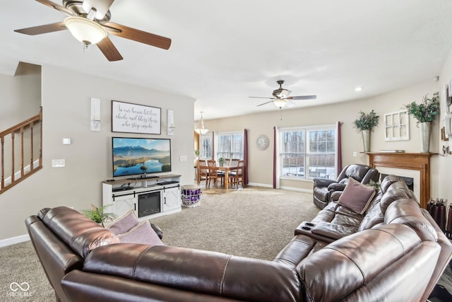 carpeted living room featuring ceiling fan, stairs, and baseboards