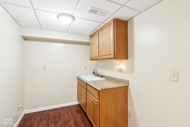 laundry room featuring dark wood-style floors, baseboards, visible vents, and a sink