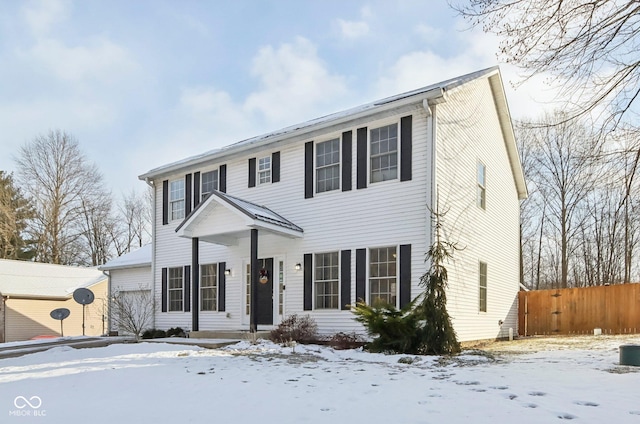 colonial-style house with fence and a garage