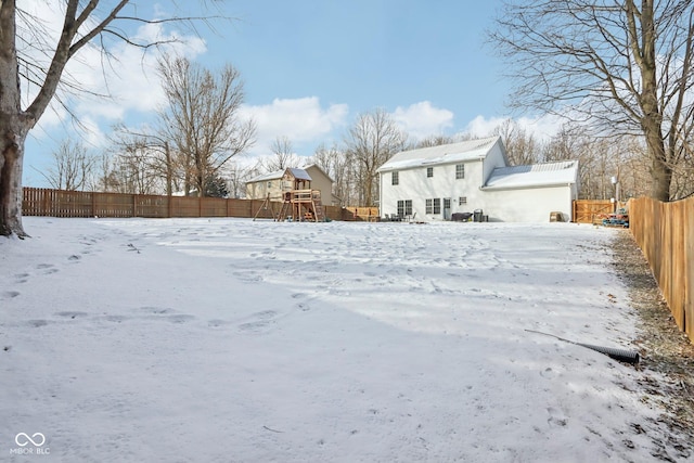 snowy yard with a fenced backyard