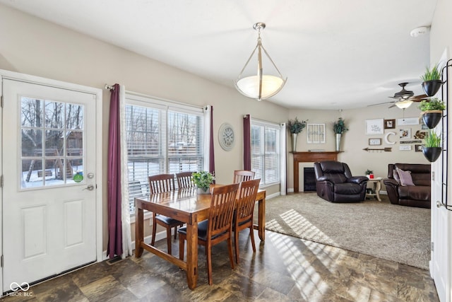 dining space featuring baseboards, dark colored carpet, and stone finish flooring