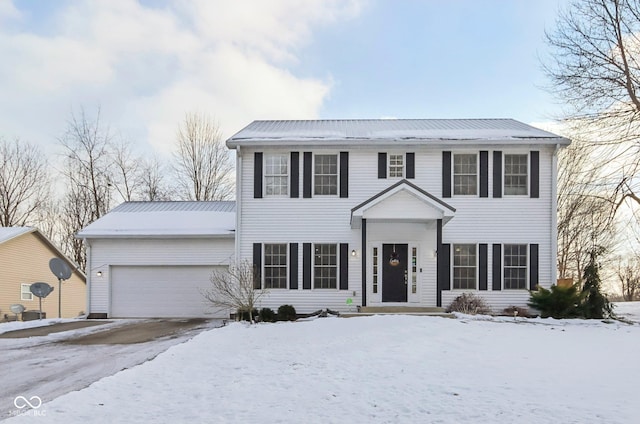 colonial-style house with an attached garage and metal roof