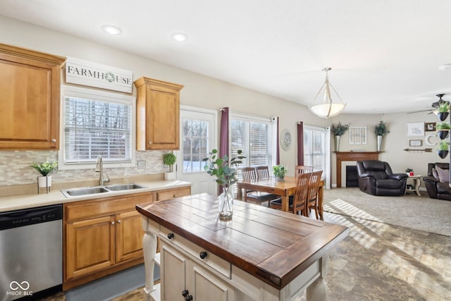 kitchen featuring tasteful backsplash, open floor plan, dishwasher, wood counters, and a sink