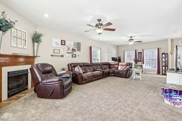 living area with a fireplace, a ceiling fan, and carpet floors