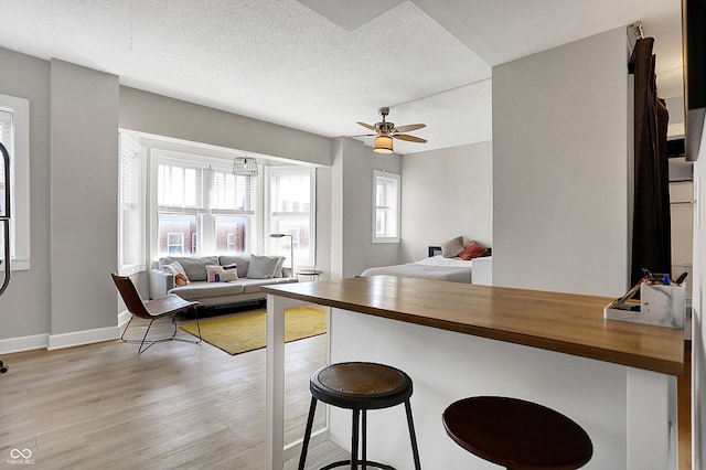 kitchen featuring a breakfast bar area, light wood-type flooring, butcher block countertops, and open floor plan