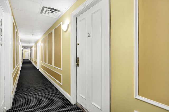 corridor featuring visible vents and a decorative wall